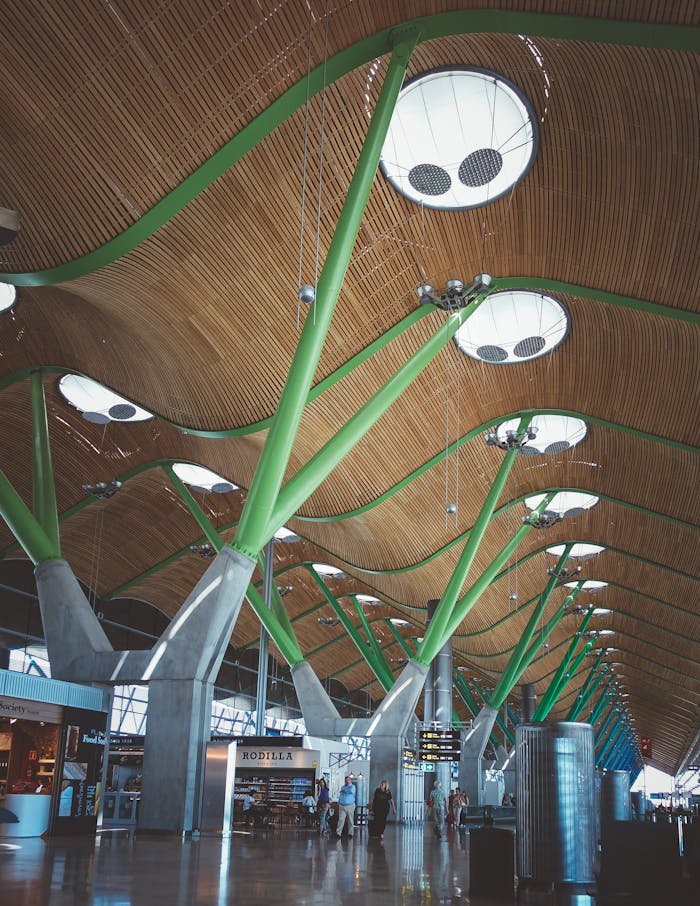 Capture of Madrid Airport's modern architectural interior with wooden ceiling and green supports.
