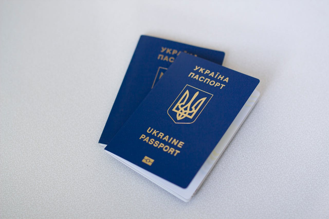 Blue Ukrainian passports on a light surface, highlighting travel documents.